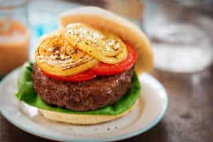 hamburger topped with tomatoes and grilled onions